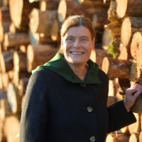 Mindy Konwitschny vor einem Holzstapel