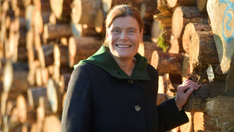 Mindy Konwitschny vor einem Holzstapel